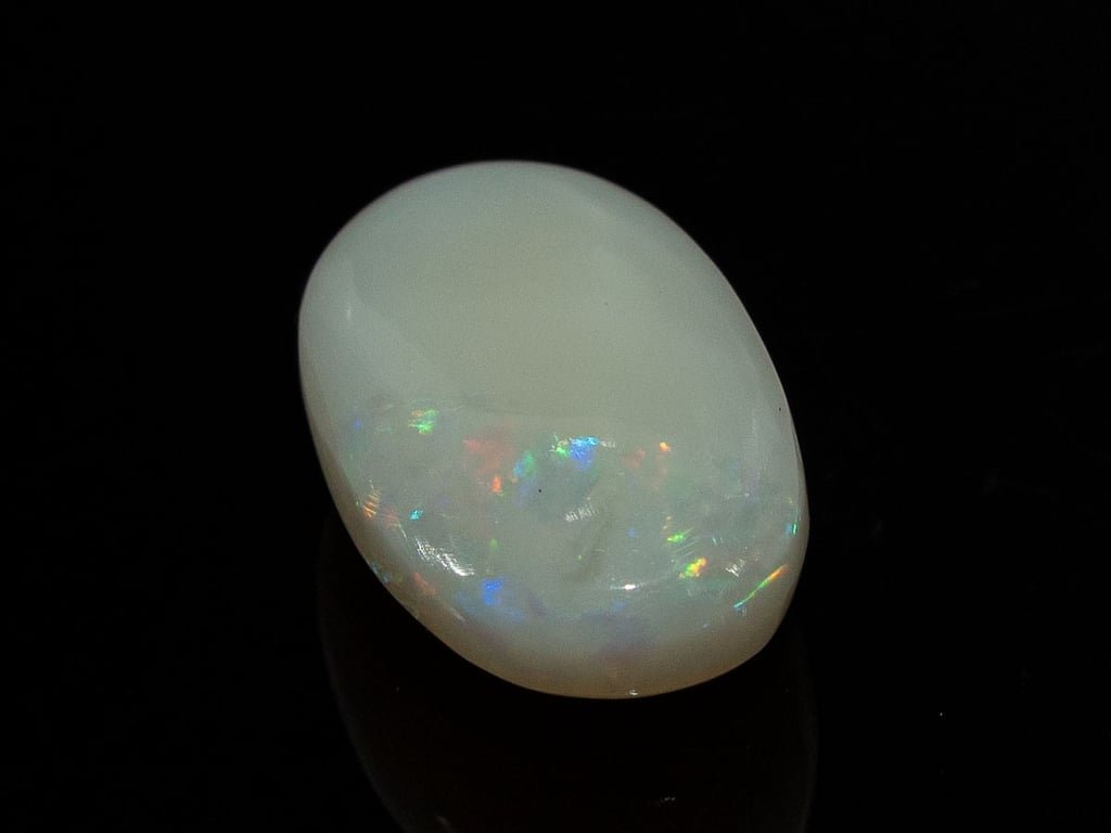 Natural Australian White Opal Stone 7.25 Carat top view: white body with a bright multicoloured patch at one end