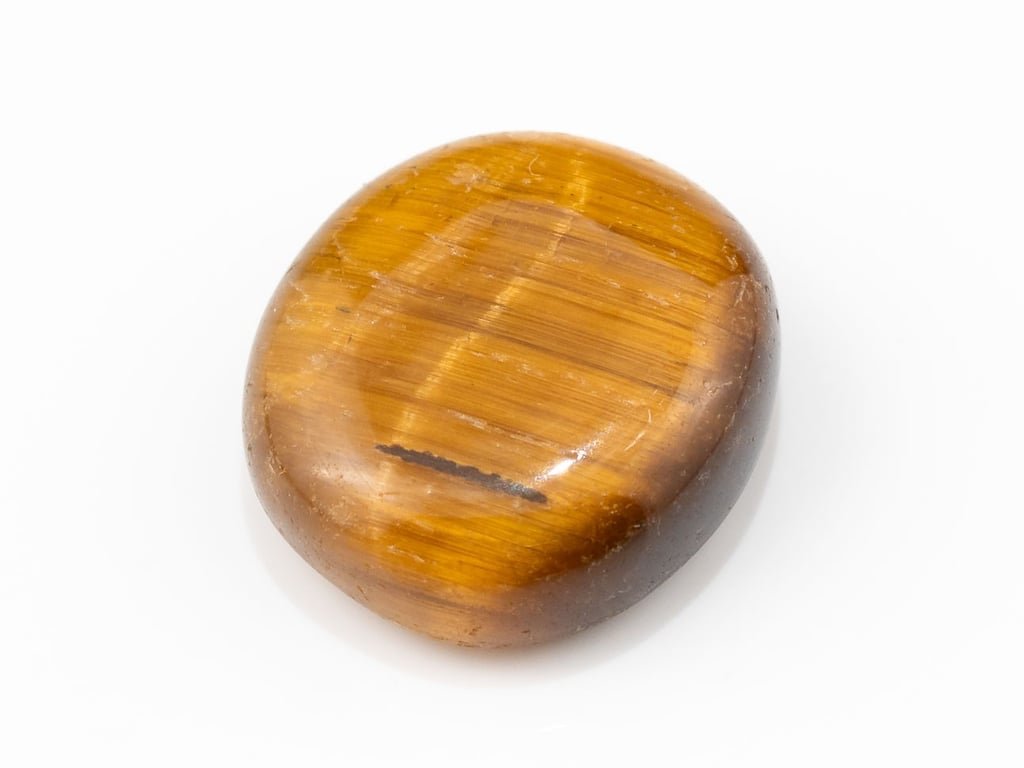 Tiger Eye Stone (Chitti) 7.40 carat, top view, golden brown oval cabochon with its band of light