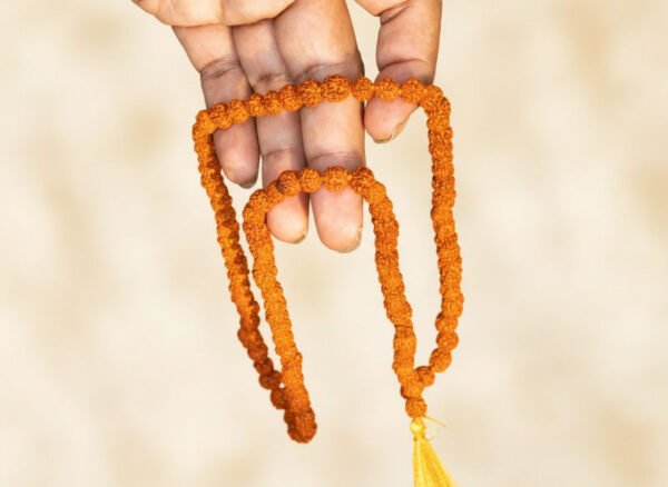 Nepali Rudraksha Mala held in hand showing 5 Mukhi beads and yellow tassel