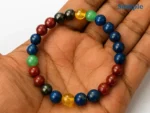 Natural seven chakra bracelet held in palm for size reference