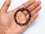 amethyst bracelet held in palm for size reference
