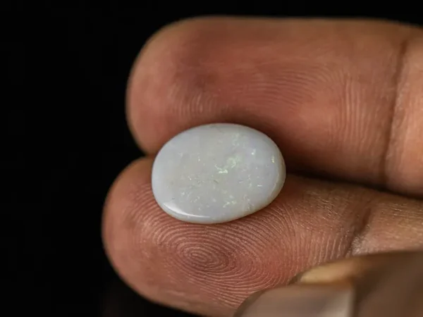 Holding a certified 3.81 Carat (4.19 Ratti) Australian Fire Opal