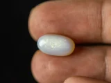 Holding a certified 4.64 Carat (5.10 Ratti) Australian Fire Opal