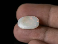 Holding a certified 5.79 Carat (6.36 Ratti) Australian Fire Opal