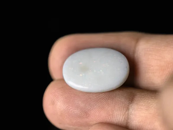 Holding a certified 8.56 Carat (9.41 Ratti) Australian Fire Opal