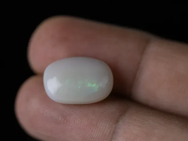 Holding a certified 9.46 Carat (10.39 Ratti) Australian Fire Opal