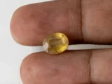 Holding a certified 5.34 ratti yellow sapphire from Ratna Gems