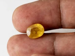 Holding a certified 5.45 ratti yellow sapphire from Ratna Gems