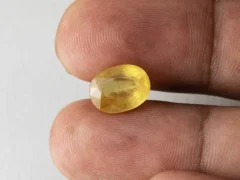 Holding a certified 5.90 ratti yellow sapphire from Ratna Gems