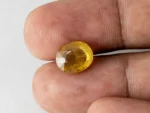 Holding a certified 6.02 ratti yellow sapphire from Ratna Gems