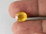 Holding a certified 6.18 ratti yellow sapphire from Ratna Gems