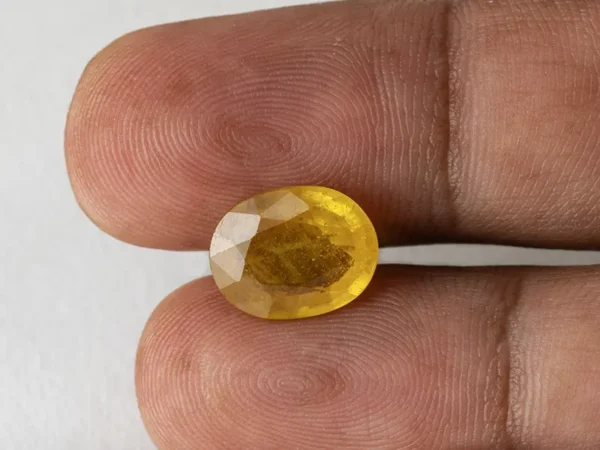 Holding a certified 7.54 ratti pukhraj stone from Ratna Gems