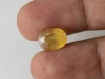 Holding a certified 7.63 ratti pukhraj stone from Ratna Gems