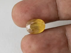 Holding a certified 7.63 ratti pukhraj stone from Ratna Gems