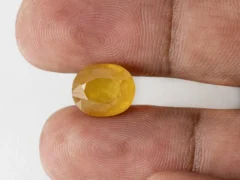 Holding a certified 8.59 ratti pukhraj stone from Ratna Gems