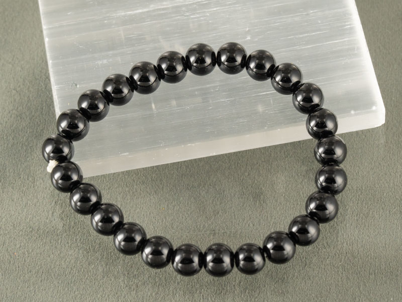 Natural Black Obsidian Bracelet (8mm) – Certified Protection Stone 3 Black Obsidian bead bracelet displayed on selenite plate