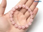 rose quartz bracelet held in palm for size reference