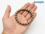 Natural 163.10 carat pyrite bracelet held in palm for size reference