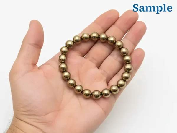 Natural 163.10 carat pyrite bracelet held in palm for size reference