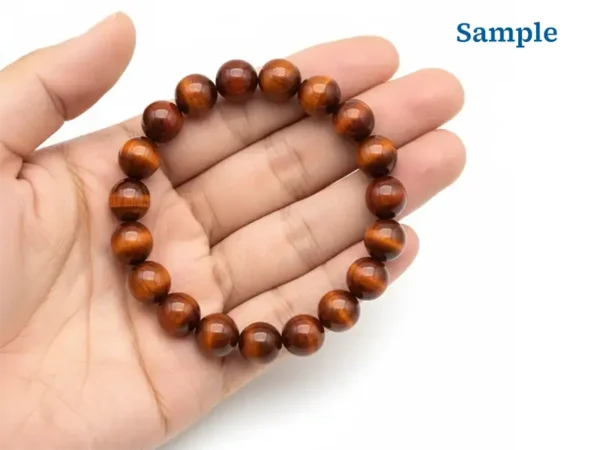 red tiger eye bracelet held in palm for size reference