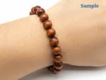 wearing a natural red tiger eye bracelet on wrist