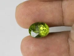 Peridot Stone 7.78 Carat (8.55 Ratti) in hand for real-life scale and color