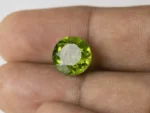 Peridot Stone 8.25 Carat (9.07 Ratti) in hand for real-life scale and color