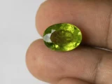 Peridot Stone 9.28 Carat (10.20 Ratti) in hand for real-life scale and color
