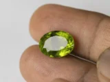 Peridot Stone 9.73 Carat (10.69 Ratti) in hand for real-life scale and color