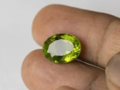 Peridot Stone 9.73 Carat (10.69 Ratti) in hand for real-life scale and color