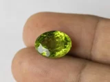 Peridot Stone 9.98 Carat (10.97 Ratti) in hand for real-life scale and color