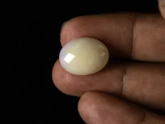 Ethiopian Fire Opal 11.06 carat in hand showing 19.8mm actual size