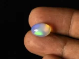 Ethiopian Fire Opal 4.73 Carat in hand showing real size 13.3x9.4mm spread