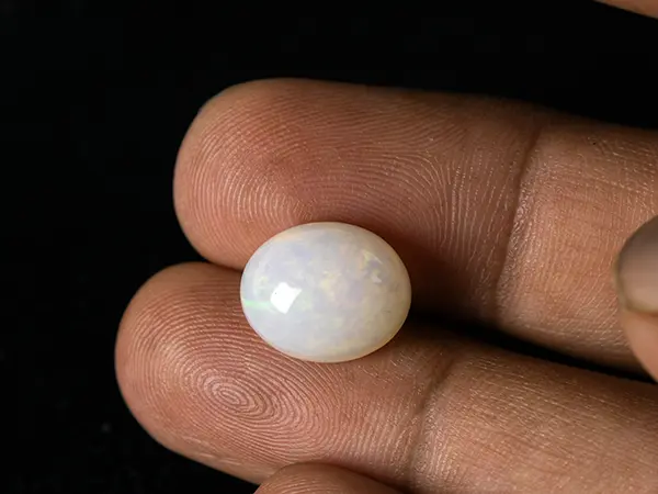 Ethiopian Fire Opal 6.60 Carat (7.25 Ratti) — Oval Cut 3 Ethiopian Fire Opal 6.60 Carat in hand showing actual size 14.2x11.7mm spread