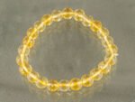 Top view of round 8mm Citrine gemstone bracelet isolated on grey background