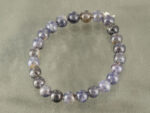 Top view of round 8mm Iolite gemstone bracelet isolated on grey background