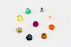 Natural Navratna Stone Set with 9 gemstones including Ruby, Pearl, Emerald, Yellow Sapphire, Blue Sapphire, Hessonite, Cat's Eye, Red Coral and American Diamond arranged in white tray