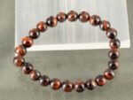 Natural Red Tiger's Eye bracelet with reddish-brown chatoyant beads on selenite