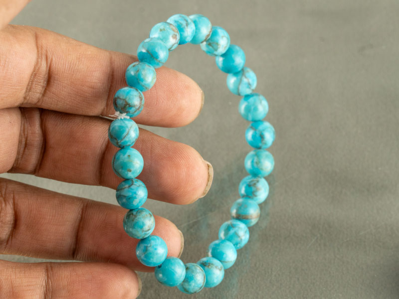 Turquoise Firoza Bracelet (Natural Quartz) – Certified 4 Hand holding sky blue Firoza bracelet showing 8mm bead size