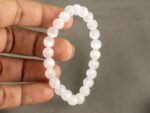 Hand holding white selenite healing bracelet showing 8mm bead size