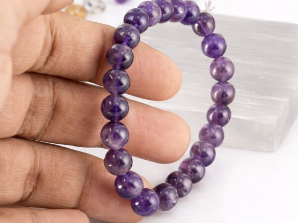 Amethyst bracelet held in hand showing bead size and color