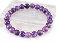 Amethyst gemstone bracelet displayed on selenite plate