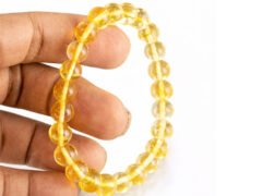 Citrine bracelet held in hand showing bead size and transparency