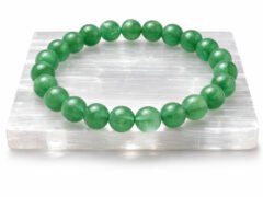 Green Aventurine gemstone bracelet displayed on selenite plate