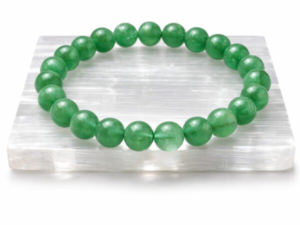 Green Aventurine gemstone bracelet displayed on selenite plate