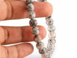 Grey Jasper bracelet held in hand showing bead size and natural texture