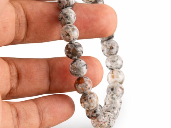 Grey Jasper bracelet held in hand showing bead size and natural texture
