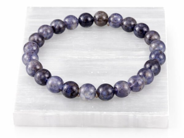Iolite Neeli gemstone bracelet displayed on selenite plate