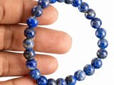 Lapis Lazuli bracelet held in hand showing bead size and natural blue color
