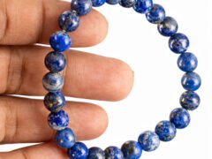 Lapis Lazuli bracelet held in hand showing bead size and natural blue color